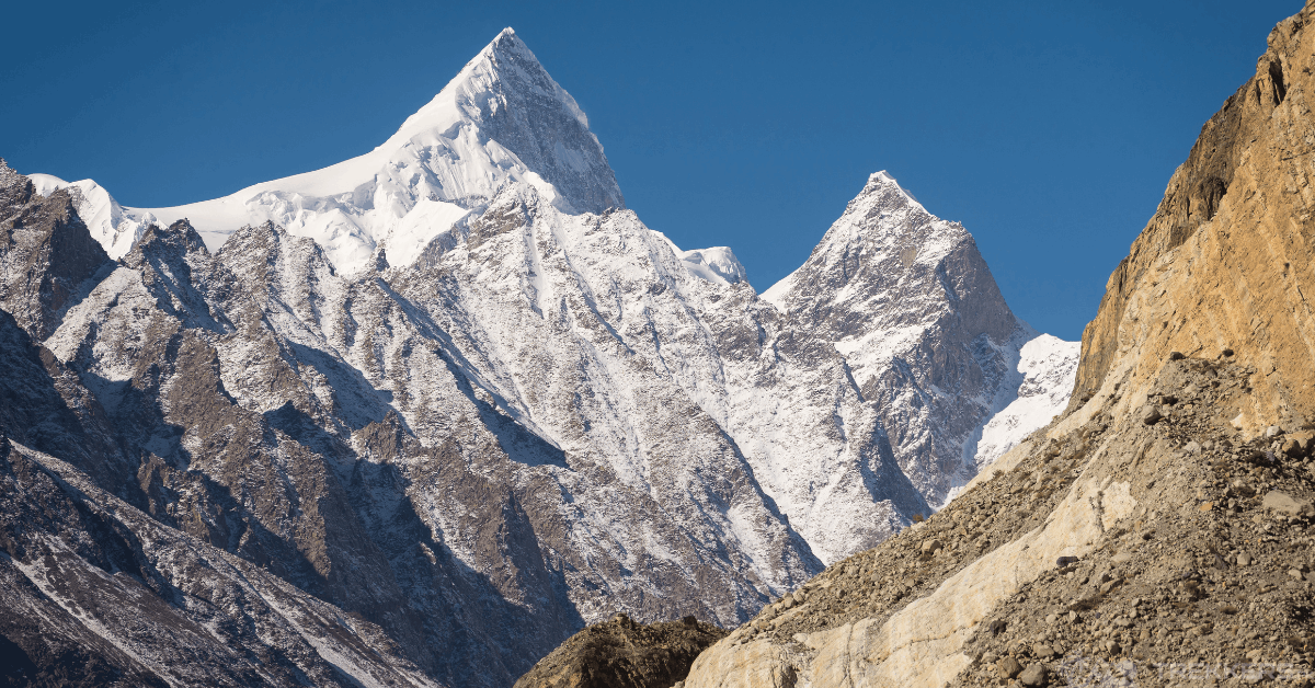 The sharp pyramid peak of Shispare Sar mountain towering over Hunza Valley during a clear day