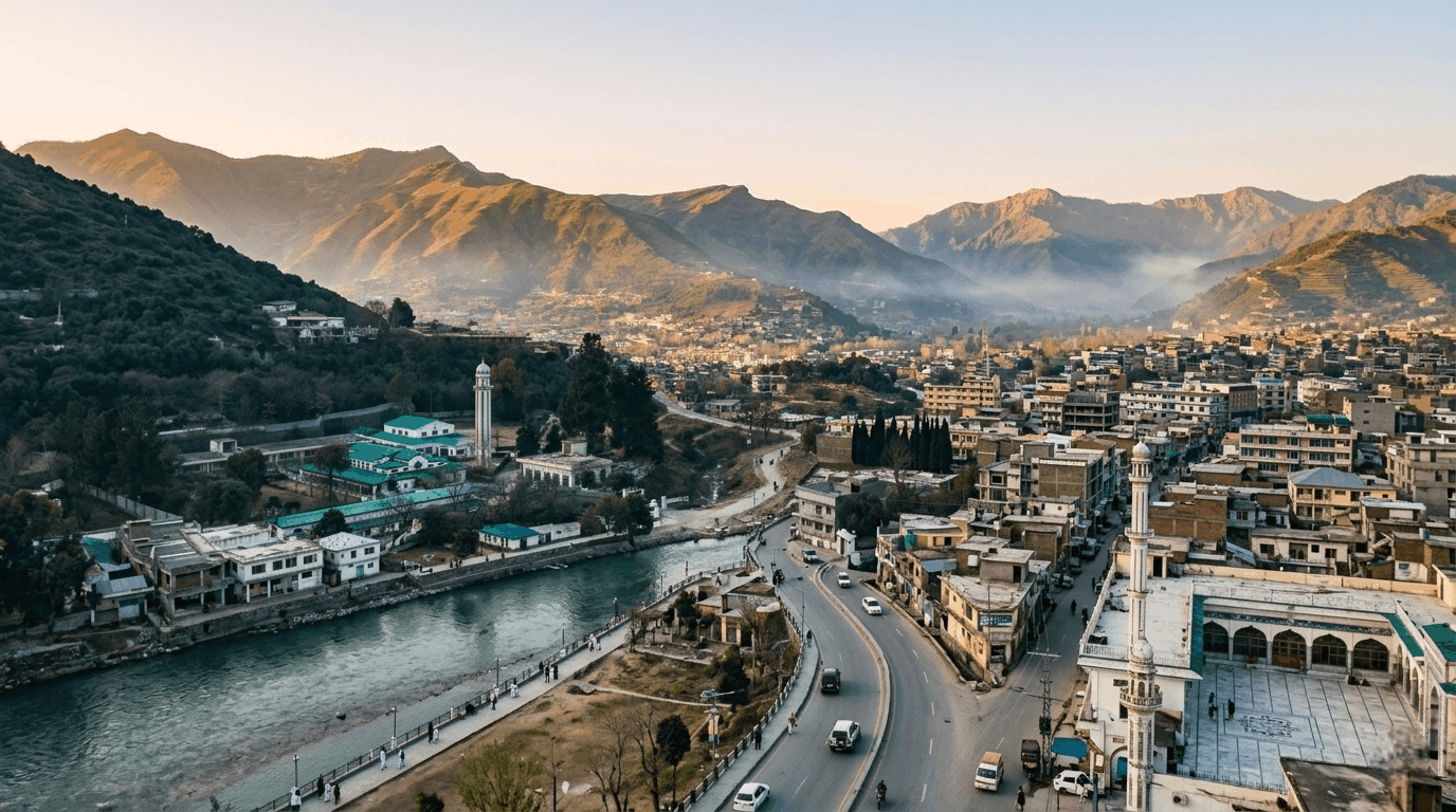 Scenic aerial view of Mingora Swat Pakistan surrounded by mountains, city buildings, and Swat Valley landscape during golden hour