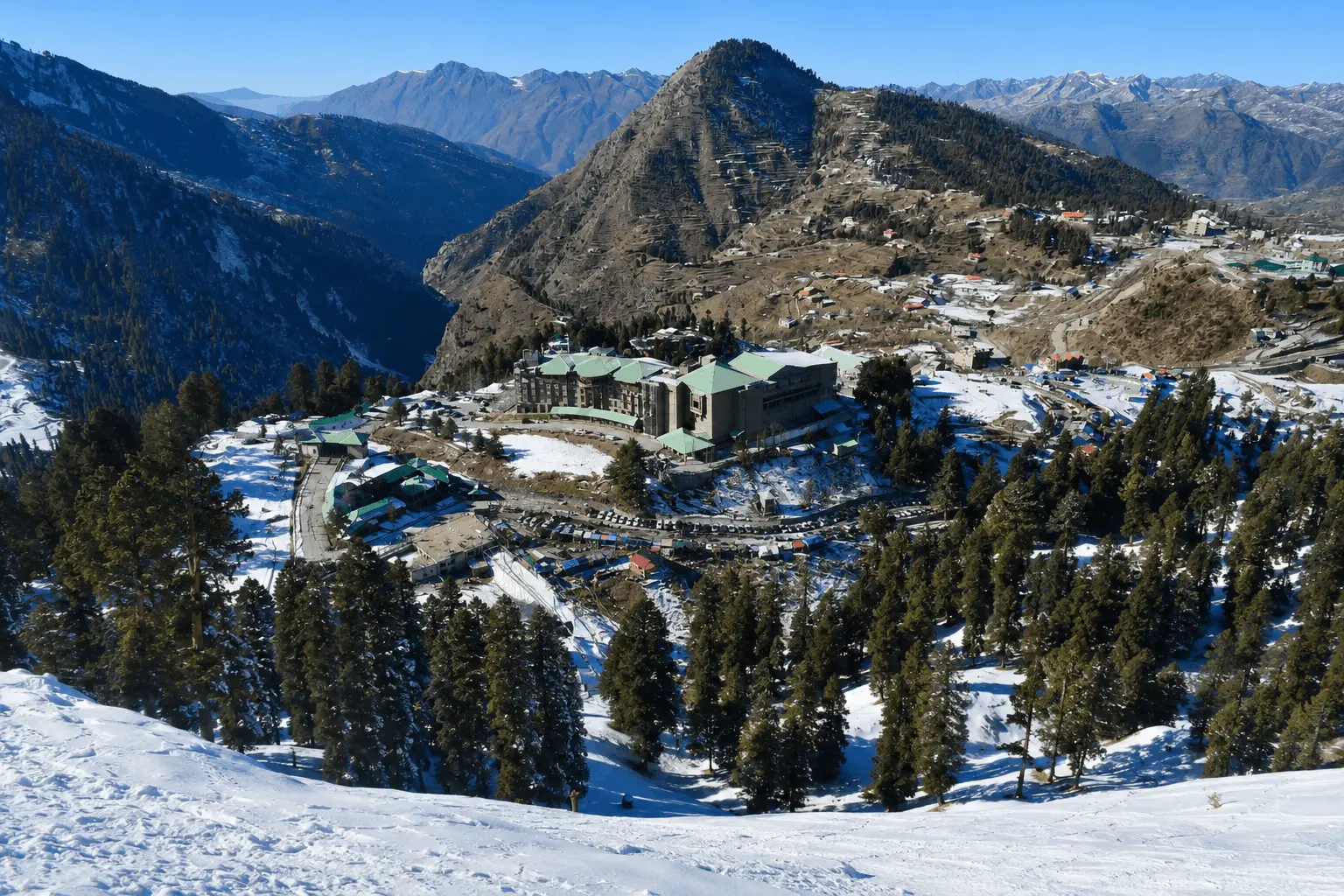 Breathtaking panoramic view of Malam Jabba Ski Resort, the Pearl Continental hotel, and snow-capped peaks.