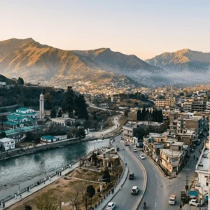 Scenic aerial view of Mingora Swat Pakistan surrounded by mountains, city buildings, and Swat Valley landscape during golden hour